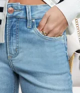 Pantalón de jean de corte recto cropped, con trabillas en la cintura, bolsillos y cierre frontal con botón y cremallera.
