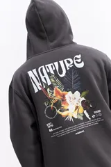 Canguro con capucha de calce regular, confeccionado en una mezcla de algodón y poliéster. Presenta un diseño estampado en la espalda con la palabra 'NATURE' en tipografía estilizada sobre un arreglo floral, acompañado de detalles gráficos y texto descriptivo de la marca Mistral.