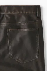 Pantalón de cinco bolsillos en tejido revestido con efecto lavado, de corte relajado y piernas rectas, con cierre de botón.