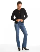 Cardigan tejido de punto color beige, con cuello a la base y cierre frontal mediante un botón metálico decorativo. Presenta mangas largas y corte recto.