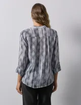 Blusa de gasa estampada multicolor, marca Ruby Rd. Tiene cuello a la base, escote en V, abertura central con botones y plisados en la parte delantera. Las mangas son 3/4 y tienen un largo regulable con presilla y botón.