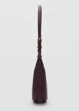 Bolso de hombro tipo hobo en color bordó, con diseño de media luna, cierre de cremallera superior y asa ajustable con hebillas metálicas.