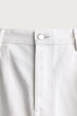Jeans relaxed fit color blanco, de corte recto y tiro medio con tejido de algodón rígido. Cuenta con cinco bolsillos, efecto ligeramente lavado, perneras con raya de planchado y cierre frontal con cremallera y botón.