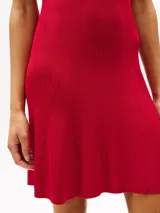 Minivestido rojo de tejido acanalado con cuello chomba, manga corta, corte evasé y botonadura dorada con logo grabado.