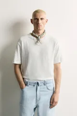 Camiseta de corte relaxed fit, confeccionada en mezcla de algodón y lino, con cuello redondo y mangas cortas.
