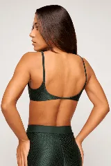 Top deportivo color verde oscuro, con tirantes finos y espalda descubierta. Diseño reversible con un lado brillante y otro con textura 3D tipo colmena.