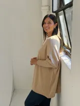 Sweater de punto color beige, con cuello redondo, mangas largas con puños acanalados y diseño holgado.