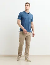 Remera polo azul marino con estampado de pequeños puntos blancos, cuello clásico con tres botones y mangas cortas.