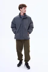 Campera puffer negra de corte estándar, con cuello alto, cierre frontal completo y puños elásticos.