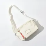 Bandolera color crema con correa larga de tela blanca regulable, cierre superior y bolsillo frontal con cierre.