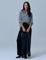 Blazer de eco cuero negro con corte oversized, cuello con solapa, cierre frontal con botones y bolsillos delanteros aplicados.