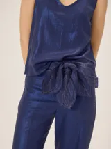 Faja de lino y algodón color azul metalizado, con diseño en forma de pétalos entrelazados y costuras pespunteadas a contratono, ideal para atar a la cintura.