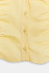 Top de cuello solapa y escote en pico, con manga corta y cierre frontal con botones. Presenta un diseño ajustado con detalles de frunces en el delantero.