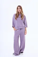 Pantalon de felpa color violeta con efecto lavado, de corte holgado y tiro medio. Cuenta con cintura elástica con cordón de ajuste y costuras laterales decorativas.