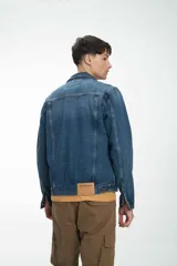 Campera de jean unisex con calce clásico, diseño de lavado claro, cierre frontal con botones metálicos y bolsillos con solapa en el pecho.