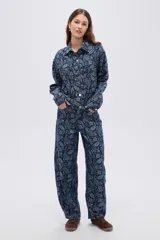 Campera de denim azul con estampado estilo paisley, cierre frontal con botones metálicos y cuello camisero.