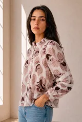 Camisa de manga larga con estampado floral en tonos azules y blancos, cuello con volados y detalles de encaje a lo largo de la botonadura y en las mangas.