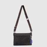 Mini cartera tipo bandolera de la marca Bubba, color azul petróleo, con correa ajustable de tela grabada con el logo de la marca. Incluye un dije colgante con la letra B en color lila y cierre superior.