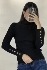 Polera de hilo blanca de cuello alto y manga larga, con detalle de botones dorados en los puños. Tejido de punto acanalado ajustado al cuerpo.