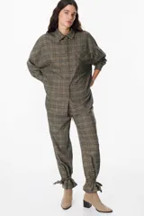 Camisa de corte oversize con estampado de cuadros, cuello clásico, cierre frontal con botones y bolsillo en el pecho.