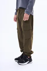 Pantalón cargo de gabardina color negro, con bolsillos laterales tipo cargo, cintura elástica con cordón ajustable y puños elásticos en los tobillos.