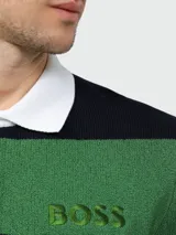 Buzo de punto a rayas horizontales verdes y azul marino, con cuello polo blanco y cierre parcial con botones. Logo 'BOSS' bordado en verde en el pecho. Corte clásico.