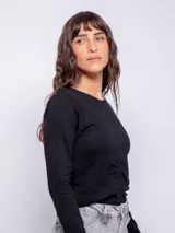 Remera blanca de manga larga con cuello redondo y frunces verticales en el centro.