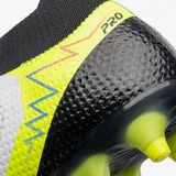 Championes de fútbol Umbro modelo Adamant, color blanco con detalles en negro, azul y amarillo neón. Presentan un diseño de media caña con cordones y tapones amarillos neón en la suela.