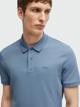 Remera polo Boss de algodón piqué color celeste, con cuello clásico, cierre frontal de dos botones, mangas cortas con ribete elástico y logo de la marca bordado en el pecho.