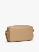 Cartera bandolera de poliuretano color beige, modelo Essential de Tommy Hilfiger, con diseño compacto de líneas redondeadas, cierre de cremallera e inscripción de la marca en bajo relieve en el frente. Cuenta con una correa cruzada ajustable de jacquard tonal.