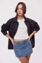Minifalda de denim con calce al cuerpo y tiro medio. Presenta bolsillos delanteros, doble botón en la cintura y aplicaciones de tachas metálicas en la cintura y los bolsillos.