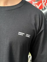 Remera negra oversize con cuello redondo y estampado pequeño en el pecho.