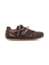 Sneaker urbano de diseño multistractural confeccionado en una combinación de cueros en tonos marrón, chocolate y tostado. Cuenta con cordones bicolores, suela dentada de goma que se extiende hacia el talón y detalles de texturas superpuestas.