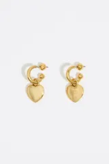 Aros de metal dorados con forma de aro y dije colgante de corazón con logo grabado. Cierre con tuerca a presión.