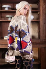 Sweater de lana tejido a mano con diseño de rombos multicolor en tonos tierra, rojo, amarillo y azul. Presenta un corte holgado, cuello redondo y puños acanalados.
