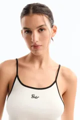 Musculosa negra de jersey de algodón con modal peruano, de calce fitted, escote en "U" y largo a la cadera. Presenta detalle de breteles y escote a contratono en blanco. Cuenta con bordado marcario a contratono en frente como distintivo.
