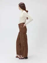 Pantalón de jean marrón de tiro medio, pierna ancha y estilo cargo con bolsillos utilitarios en las rodillas.