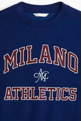 Buzo de tejido de punto color azul marino, con cuello redondo y diseño de texto universitario en el pecho que dice "MILANO ATHLETICS".