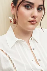 Aros colgantes con forma de flor, con pétalos color crema y marrón.