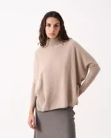 Sweater de cachemire color beige, con cuello alto acanalado y mangas ajustadas. Su diseño sin sisa crea un cuerpo amplio y suelto.