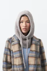 Balaclava de punto en color gris, con diseño envolvente y cordones ajustables en la parte inferior.
