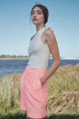 Bermuda de tiro alto color salmón con textura broderie, corte amplio, pinzas delanteras y ruedo con dobladillo.