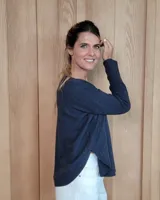 Sweater de punto color beige, con cuello en V, manga larga con puños acanalados y diseño holgado.