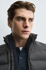 Chaleco acolchado de hombre color negro, con diseño puffer, cuello alto y cierre frontal con cremallera.