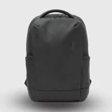 Mochila urbana de diseño minimalista en color negro, con compartimento principal con cierre, asa superior reforzada y bolsillos laterales.