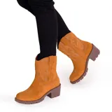 Bota corta de cuero color marrón, con taco cuadrado y punta fina. Presenta costuras decorativas de estilo western en la caña y el empeine. Cuenta con suela de goma.