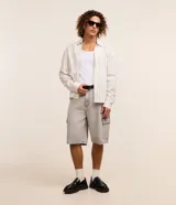Bermuda baggy cargo en jeans de color gris, con cintura con trabillas, cierre frontal de botón y cremallera, y bolsillos laterales utilitarios.
