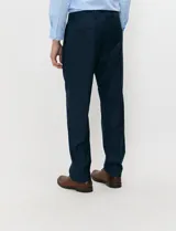 Pantalón de vestir azul marino de corte sastrero con pinza frontal, pase para cinturón, bolsillos laterales y bolsillos traseros de ojal.