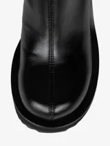 Bota negra de caña media con plataforma y cuña esculpida.
