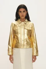 Campera de cuero negro al cuerpo, con cuello camisero, bolsillos de parche con solapa en el pecho y cierre frontal con broches a presión.